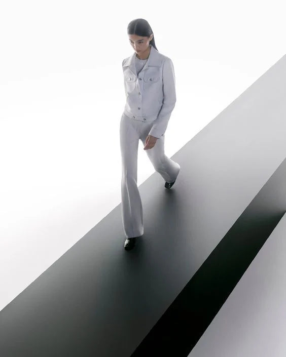 Model walking across a monumental diagonal architectural structure